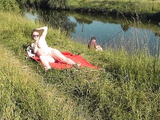 Wild seashore. Horny MILF Platinum bare sunbathing on river financial institution, random fisherman man watches. Bare in public. Nude seashore