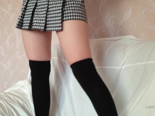A schoolgirl in uniform displays her lengthy legs