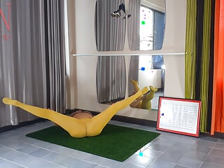 Regina Noir. Yoga in yellow tights doing yoga within the health club. 3