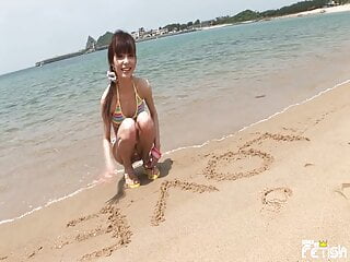 Thin Jap chick enjoys having a photoshoot on a seashore